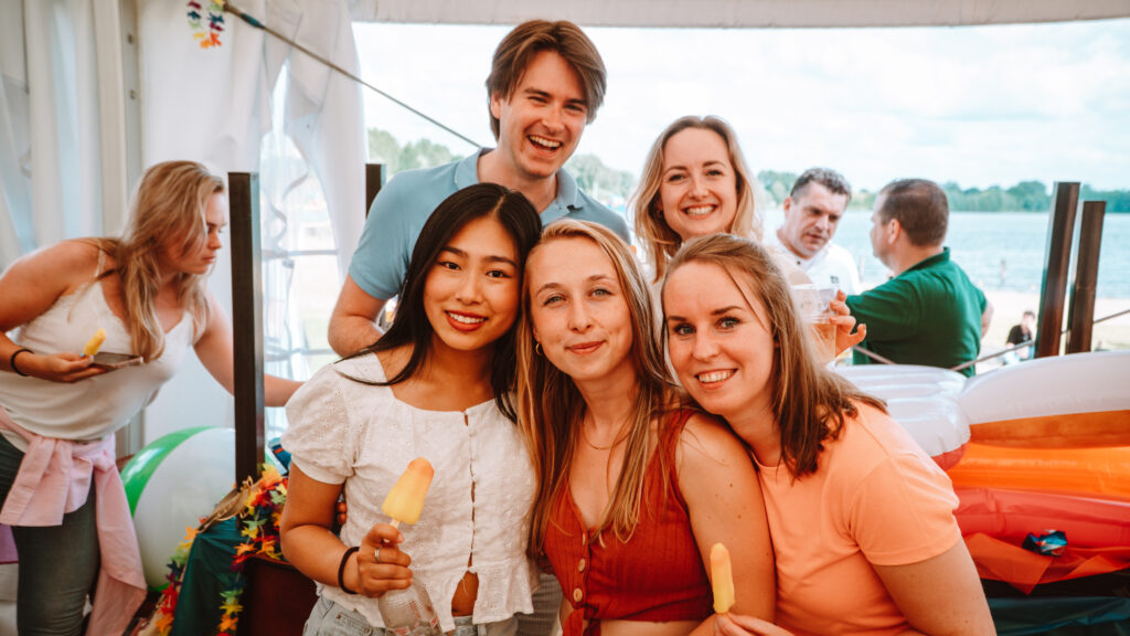 Groep viert fees tin de Beachclub en poseert voor de camera.