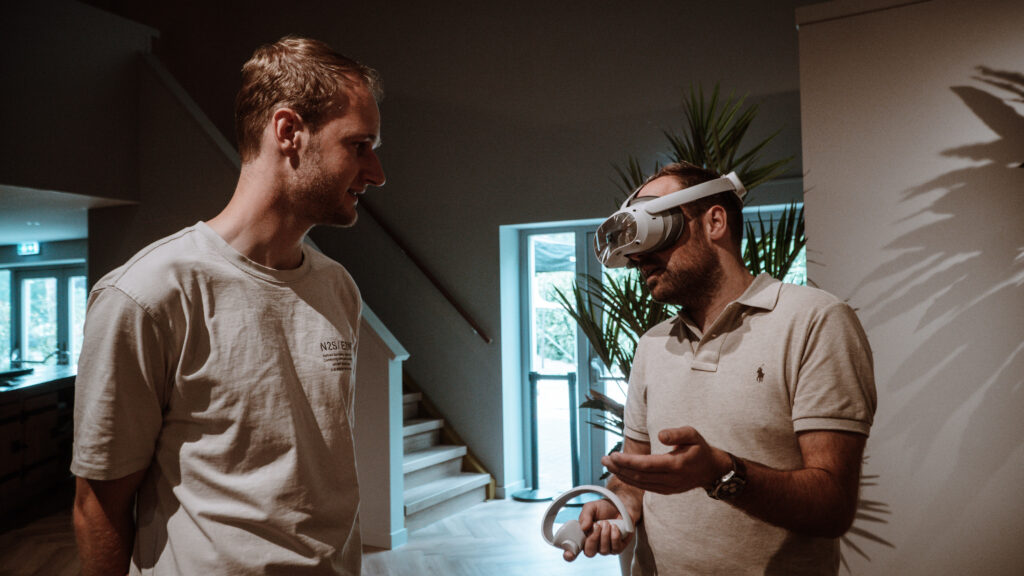 Man met VR-bril praat met man.