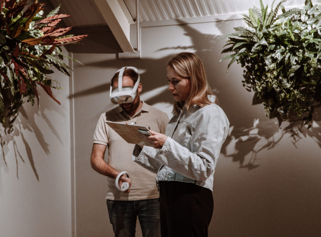 Vrouw geeft uitleg aan man met VR-bril.