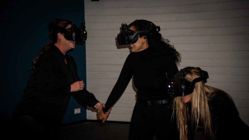 Vrouwen helpen elkaar tijdens VR-game.