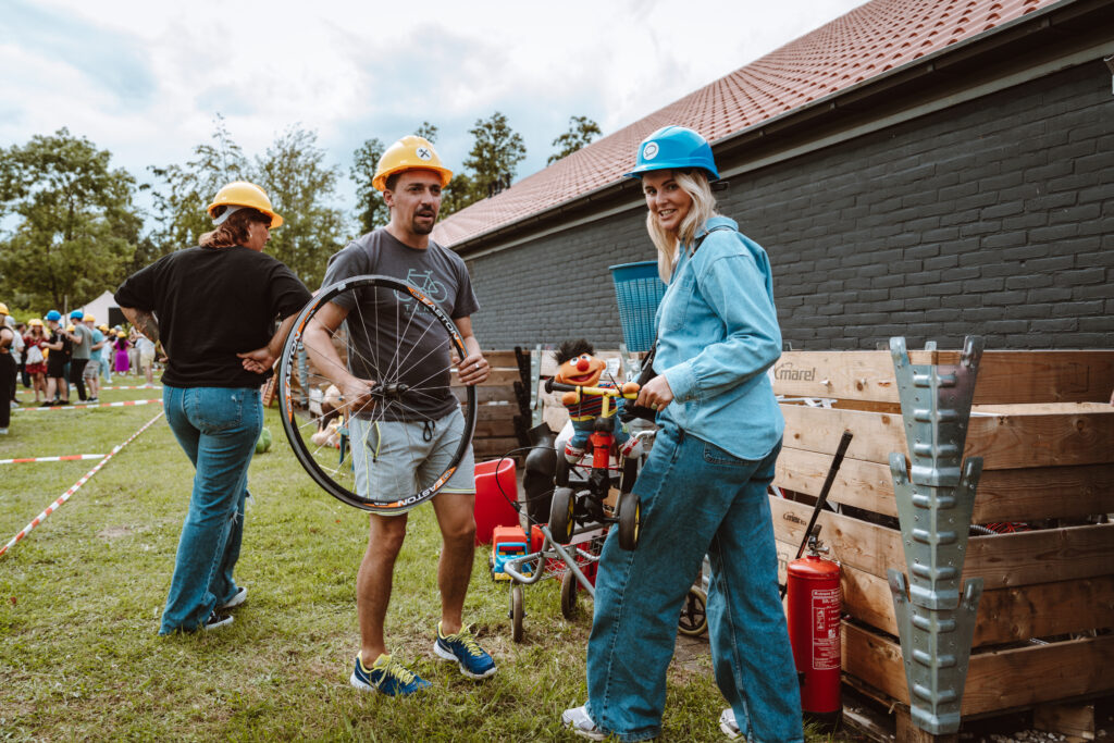 Man en vrouw overleggen over voorwerpen tijdens teambuilding Chainreaction.