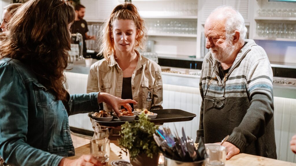 Local deelt eten uit aan twee gasten